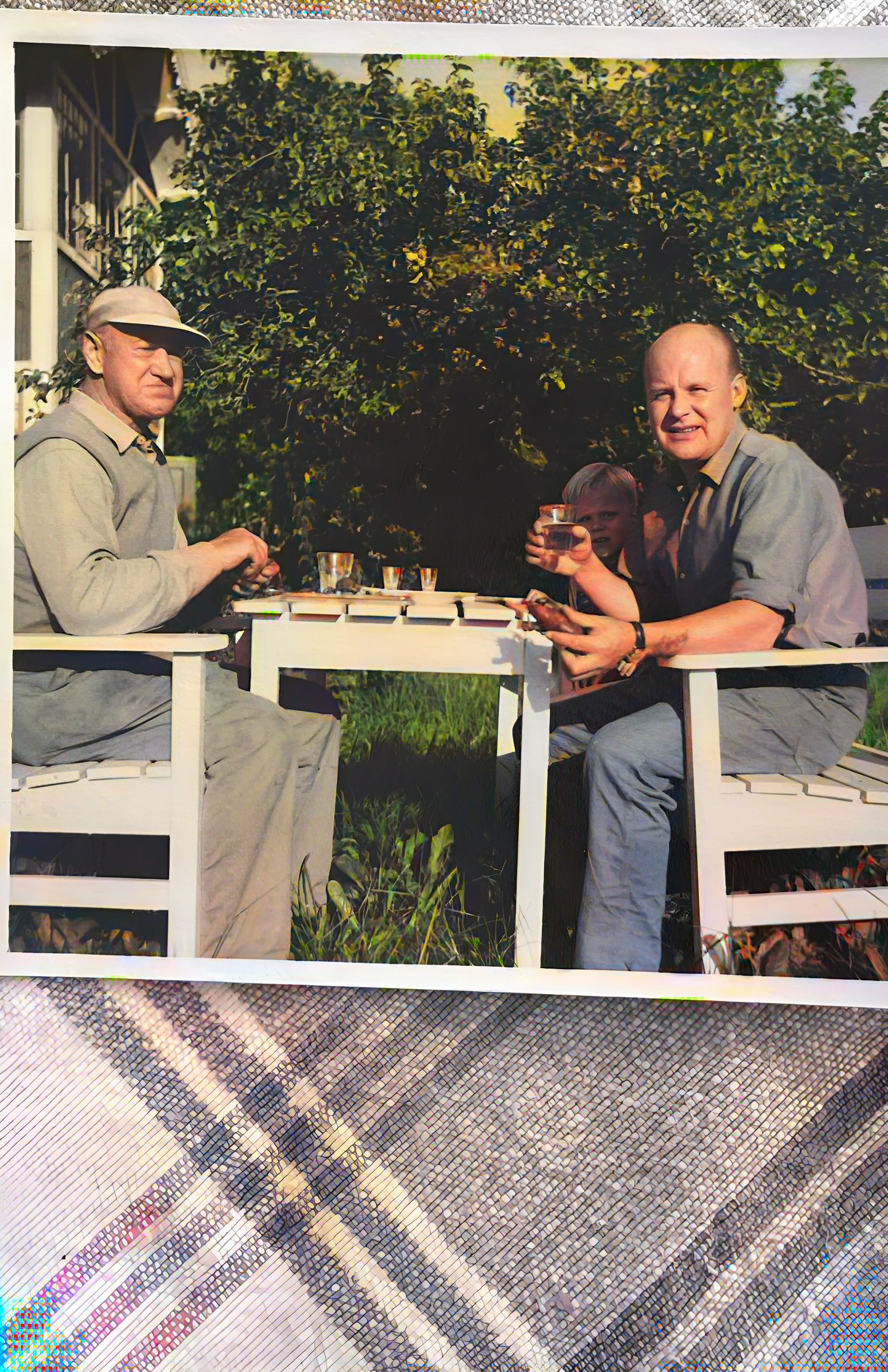 Två män dricker vid trädgårdsbord